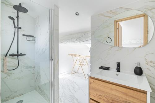 La salle de bains est pourvue d'une douche et d'un lavabo avec un miroir. dans l'établissement 15 RIOUFFE - Splendide appartement 6 couchages à 50m à pieds du Palais, à Cannes
