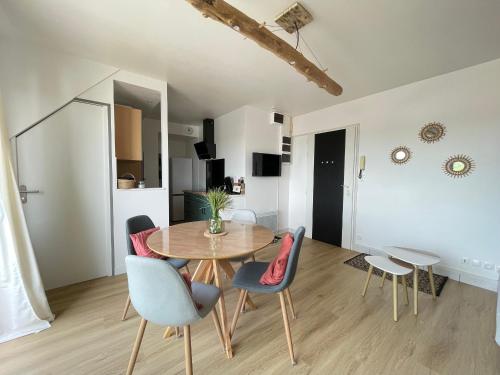 une salle à manger et un salon avec une table et des chaises dans l'établissement Duplex lumineux à St-Brevin, proche plage et commerces, parking fermé, 2/3 pers - FR-1-364-151, à Saint-Brévin-les-Pins