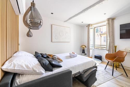 une chambre avec un lit avec des oreillers dessus dans l'établissement 15 RIOUFFE - Splendide appartement 6 couchages à 50m à pieds du Palais, à Cannes
