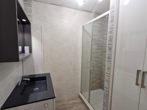une salle de bain avec une douche en verre et un lavabo dans l'établissement Appartement 2 pièces climatisé avec garage, piscine, proche commerces et plages - Sainte-Maxime - FR-1-780-66, à Sainte-Maxime