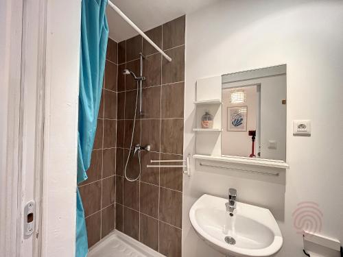 une salle de bain avec un lavabo et une douche dans l'établissement Charmant studio avec terrasse Sud, proche thermes et centre - Lamalou-les-Bains - FR-1-451-190, à Lamalou-les-Bains
