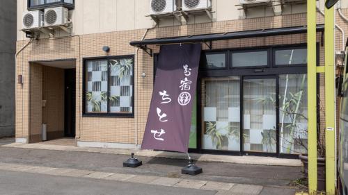a building with a banner in front of it at Tabist Oyado Chitose in Kazuno