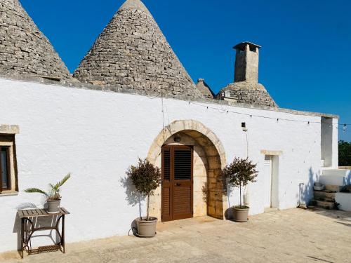 a white building with a brown door and some plants at Villa Filou in Santa Lucia