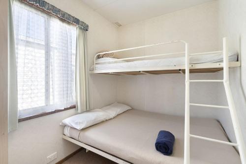 Mały pokój z łóżkiem piętrowym i oknem w obiekcie Coachstop Caravan Park w mieście Maitland