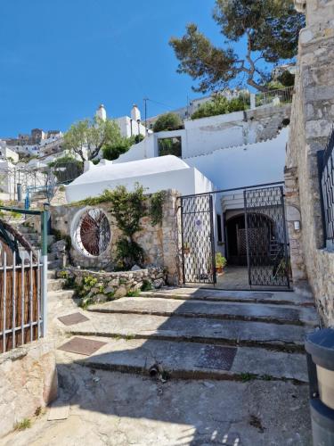 een poort naar een wit huis met trappen bij "villa MARINA" a due passi dal mare in Peschici