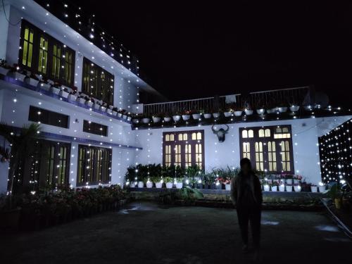 uma pessoa fica em frente a um edifício com luzes de Natal em Shunyu Homestay, Mima em Kohīma