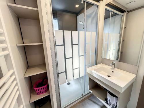 une salle de bain avec un lavabo et une douche dans l'établissement Chalet cosy 4 pers - Piscine chauffée - Proche plage et commerces - Terrasse et jardin privés - FR-1-361-504, à Jullouville