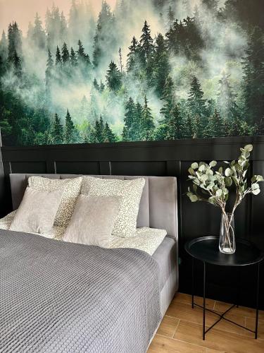 a bedroom with a large painting of a forest at Apartament Przytulny 5 - Las, self check in, dworzec PKP in Rzeszów
