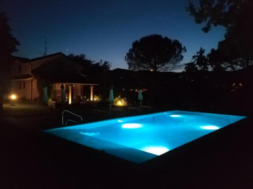 - une piscine bleue dans l'obscurité la nuit dans l'établissement Villa delle rose Brisighella, à Brisighella