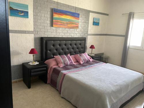 1 dormitorio con 1 cama grande con almohadas rosas en Casa Vila Sao & Pompeia, en Sesimbra