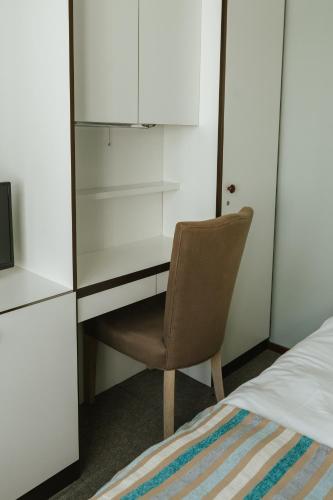 a bedroom with a desk and a chair next to a bed at Hotel Kempenrust in Kasterlee