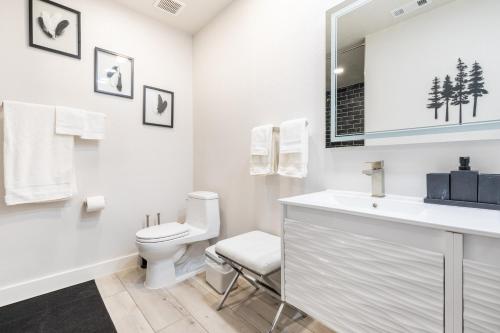 a white bathroom with a toilet and a sink at Rolling Oaks Ranch - 200 Acres of Lakeside Beauty & Countryside Serenity in Mariposa