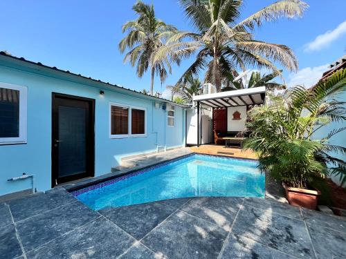 a swimming pool in front of a house at Mermaid Island Beach Resorts in Puducherry