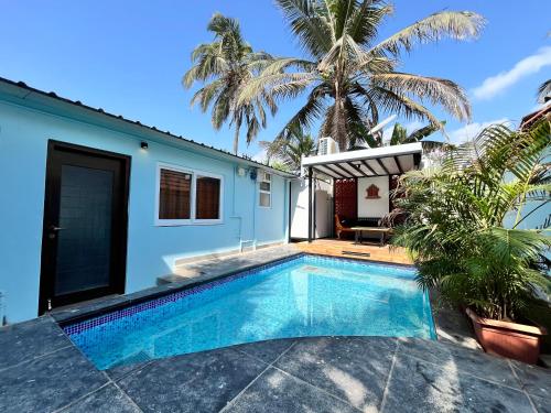 a swimming pool in front of a house at Mermaid Island Beach Resorts in Puducherry