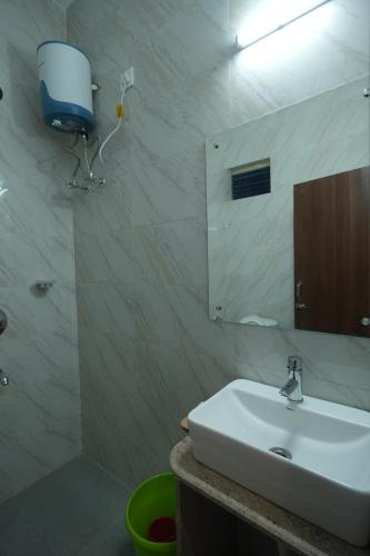 a bathroom with a white sink and a mirror at Hotel New Sagar Priya in Digha