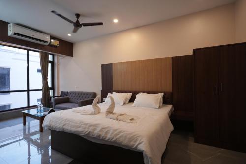 a bedroom with a bed with two cats laying on it at Hotel New Sagar Priya in Digha