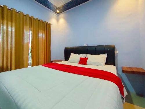 Wates的住宿－RedDoorz Syariah Near Stasiun Wates，一间卧室配有一张带红色毯子的大床