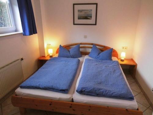 1 Schlafzimmer mit 2 Betten und blauen Kissen in der Unterkunft Hygge in Nebel