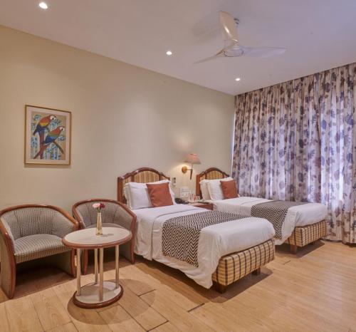 Habitación de hotel con 2 camas y mesa en Regent Hotel Andheri, en Bombay
