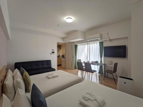 um quarto de hotel com duas camas e uma sala de estar em ESLEAD HOTEL Namba South Ⅱ em Osaka