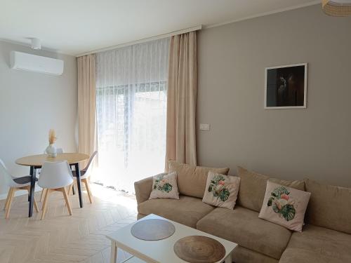 ein Wohnzimmer mit einem Sofa und einem Tisch in der Unterkunft Apartament Ustrońska Jodełka z Sauną-Nadrzeczna in Ustroń