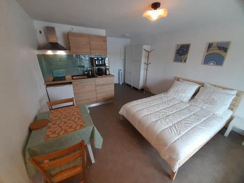 une chambre avec un grand lit blanc et une table dans l'établissement Studio moderne rénové au bord du lac pour deux personnes à Vieux Boucau - FR-1-239-991, à Soustons