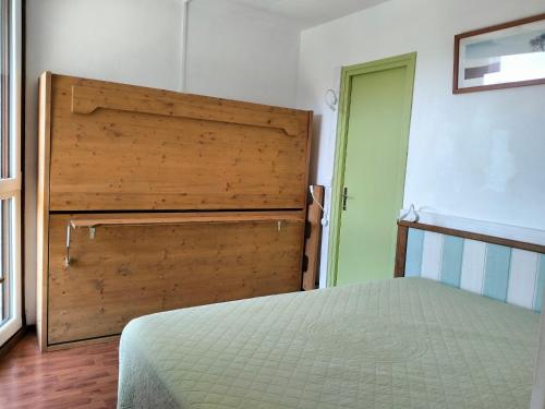 une chambre avec un lit et une tête de lit en bois dans l'établissement Charmant T2 aux Balcons de Villard, idéal pour 4-6 pers, avec balcon sud et à proximité des pistes - FR-1-761-8, à Villard-de-Lans