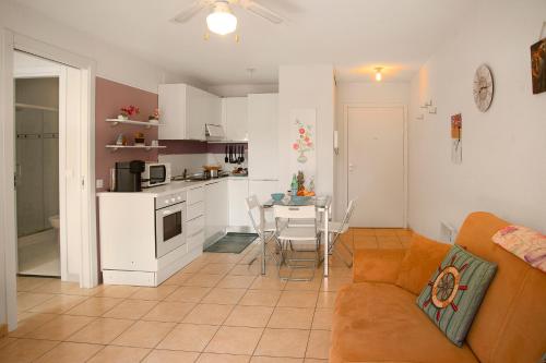 Il dispose d'une cuisine et d'un salon avec un canapé et une table. dans l'établissement Royale Sejour - Happy Rentals, à Menton