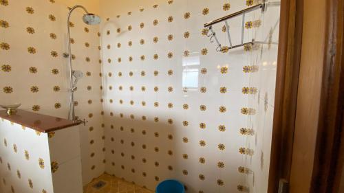a bathroom with a shower with bees on the wall at The Magnolia Lodge in Almora