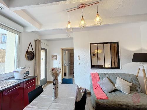 un salon avec un canapé et une table dans l'établissement Appartement F2 Climatisé avec Terrasse à 100m des Thermes et du Centre de Lamalou-les-Bains - FR-1-451-201, à Lamalou-les-Bains