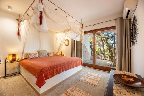 a bedroom with a canopy bed and a balcony at El Dorado in Es Pujols