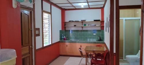 Una cocina con una mesa, un fregadero y un inodoro. en Mango House Apartments, en Panglao