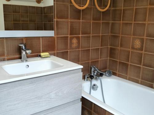 a bathroom with a sink and a bath tub at Appartement Corrençon-en-Vercors, 3 pièces, 8 personnes - FR-1-761-21 in Corrençon-en-Vercors