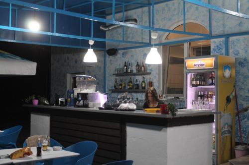 a woman sitting at a bar in a restaurant at Pensiunea Hyperion Cormaia in Sîngeorz-Băi