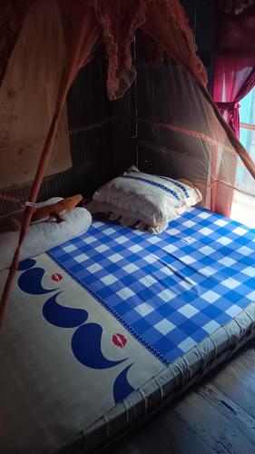 a bed in a tent with a blue and white mattress at Khalisa Homestay in Komodo