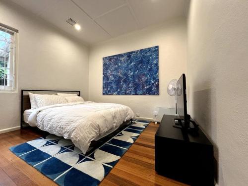 1 dormitorio con 1 cama y una pintura en la pared en Princes Cottage In Prahran, On Chapel St, en Melbourne