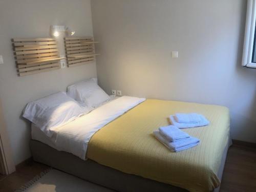 a bed in a room with two towels on it at Sea Breeze Holiday Home in Monemvasia