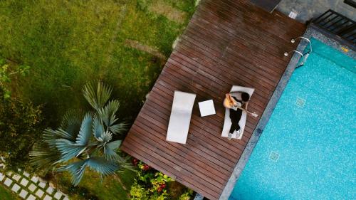 a woman sitting on a bench next to a pool at Blanket Days Resort and Spa in Thekkady