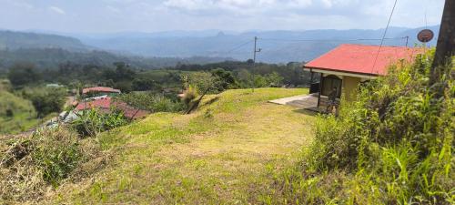 a house with a red roof on top of a hill at CASA DE CAMPO in Turrialba