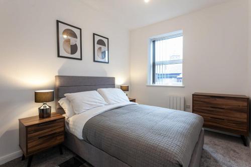 a bedroom with a bed and a dresser and a window at Fantastic 1 Bedroom Apartment in Bolton in Bolton