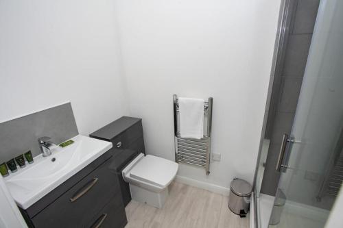 y baño con lavabo, aseo y ducha. en Modern 1 Bedroom Apartment in Bolton, en Bolton