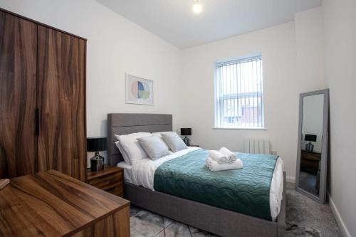 a bedroom with a bed with two towels on it at Modern 1 Bedroom Apartment in Bolton in Bolton