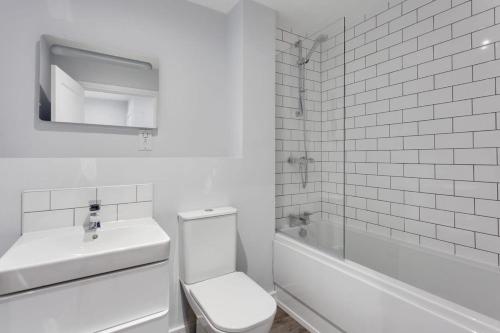 a white bathroom with a toilet and a sink at Modern 1 Bedroom Flat In Central Birmingham in Birmingham