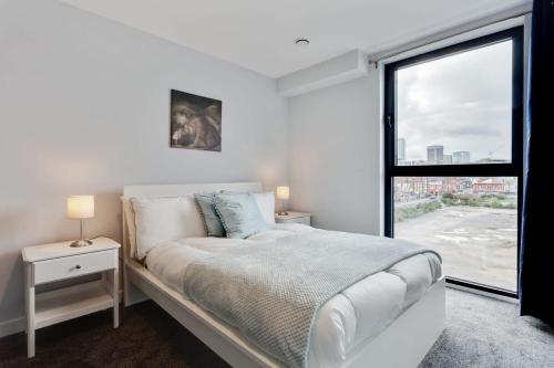 a white bedroom with a bed and a window at Modern 1 Bedroom Flat In Central Birmingham in Birmingham
