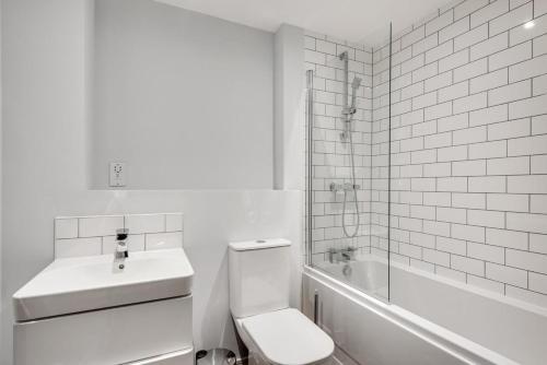 een witte badkamer met een toilet en een wastafel bij Beautiful 1 Bedroom Flat in Central Birmingham in Birmingham