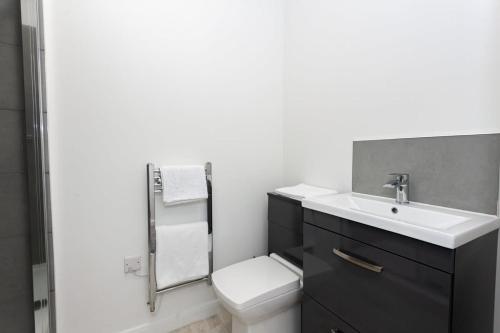 een witte badkamer met een wastafel en een toilet bij Fantastic 1 bedroom apartment in Bolton in Bolton