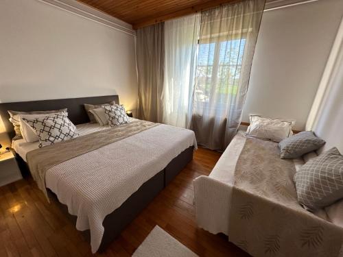 a bedroom with two beds and a window at Sunny Hill Apartment in Ilirska Bistrica