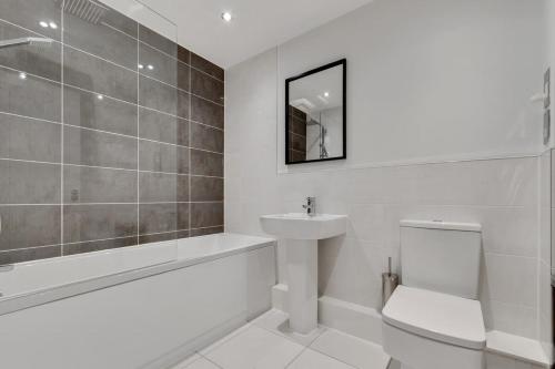 a white bathroom with a sink and a toilet at 1 Bed Modern Apartment in a Converted Mill in Leeds