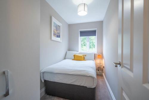 een kleine slaapkamer met een klein bed met een geel kussen bij Fantastic 3BR House in Birmingham With Garden in Birmingham