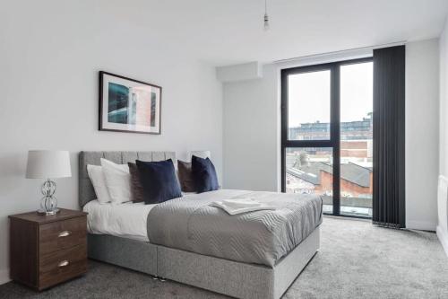 a bedroom with a bed and a large window at Stunning 2br Flat in the Centre of Birmingham in Birmingham